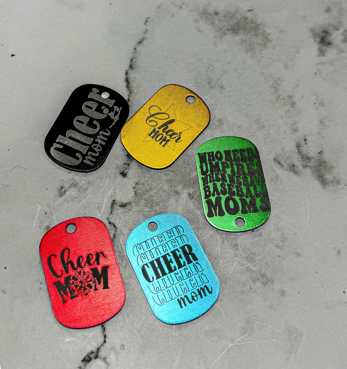 four dog tags that say cheer mom on them
