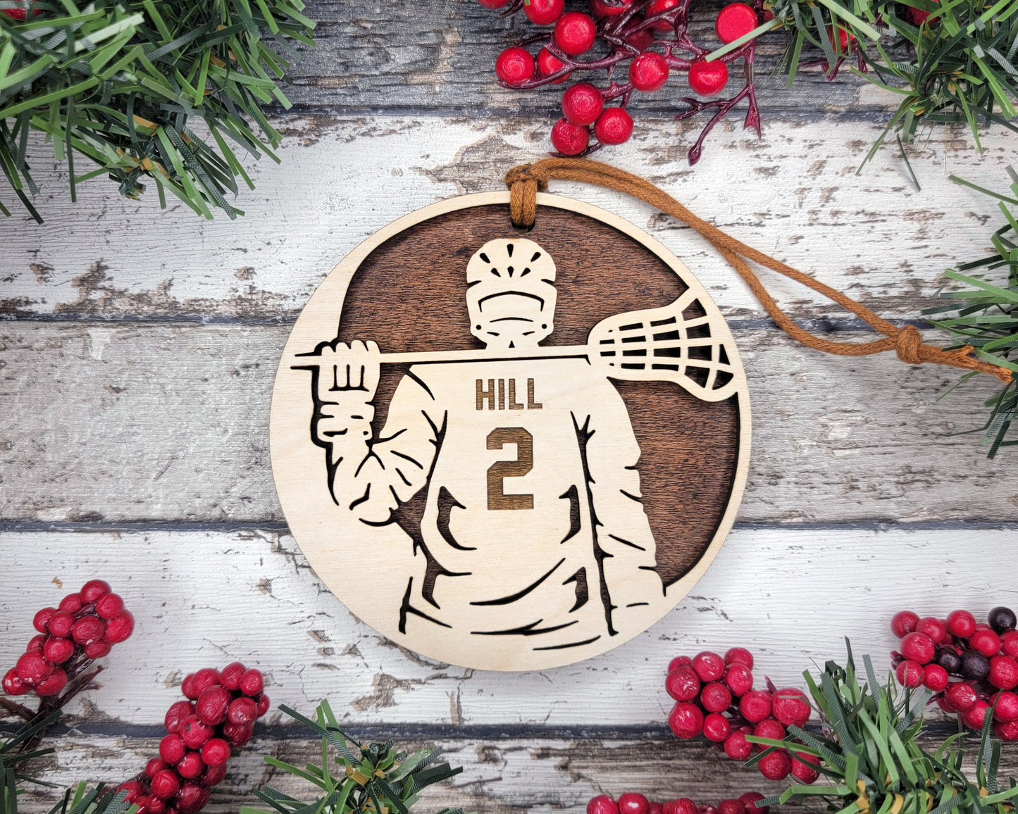 a wooden ornament with a picture of a lacrosse player