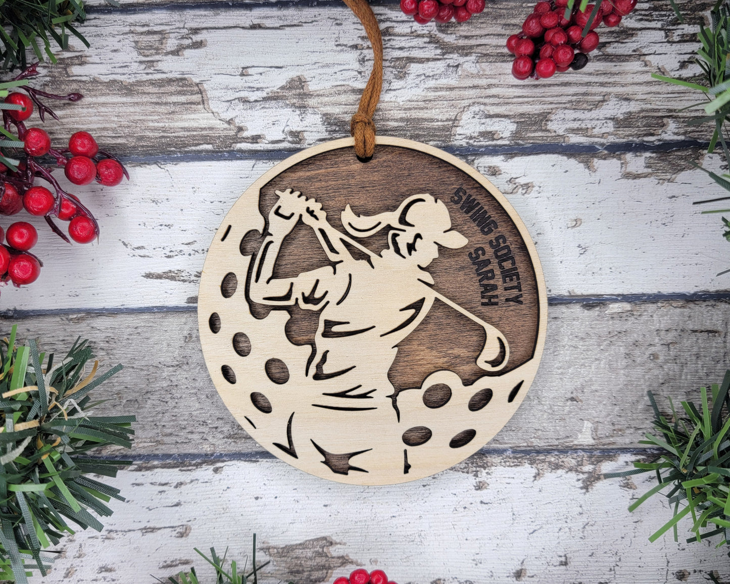 a wooden ornament with a picture of a woman playing golf