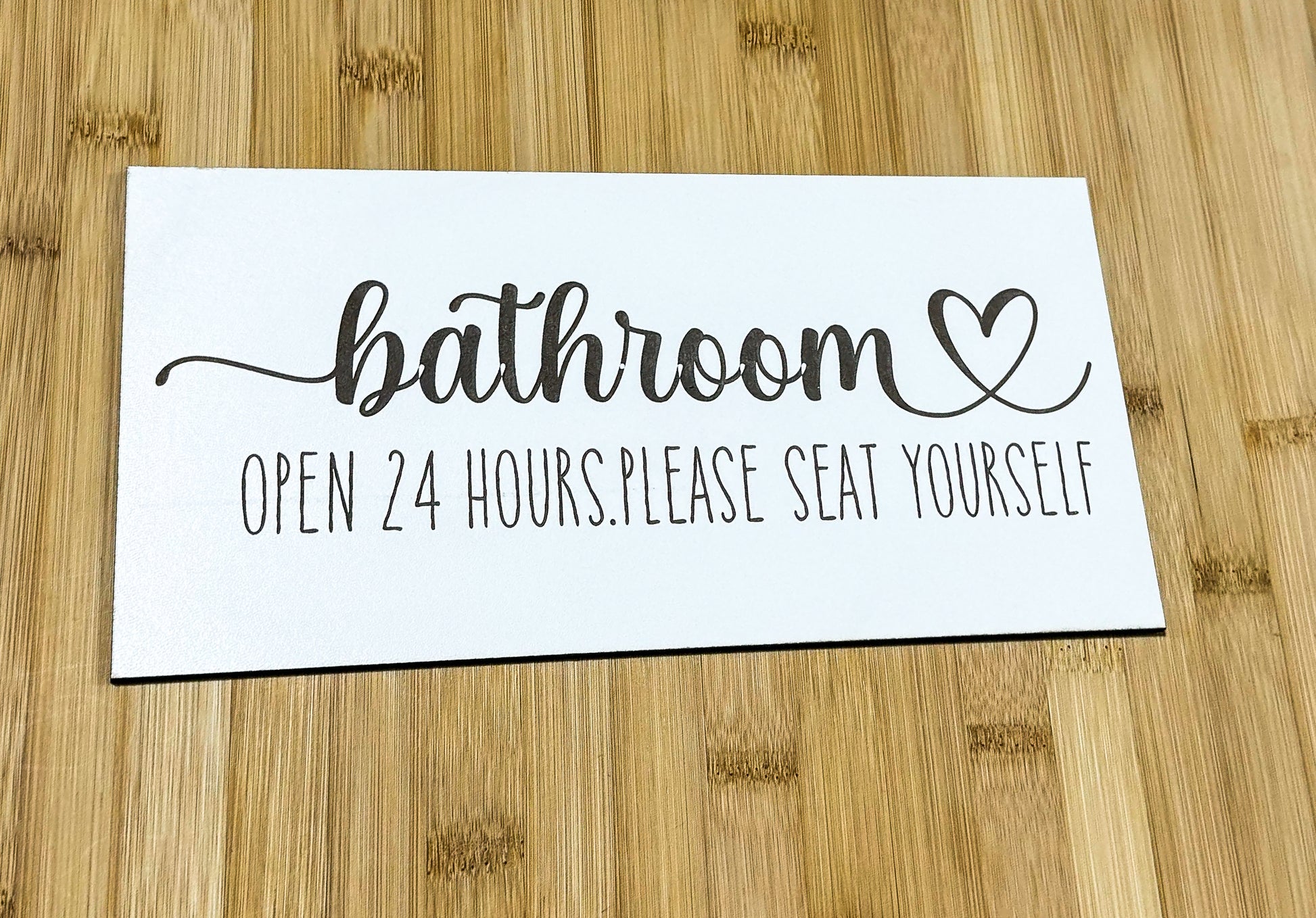 a bathroom sign sitting on top of a wooden table