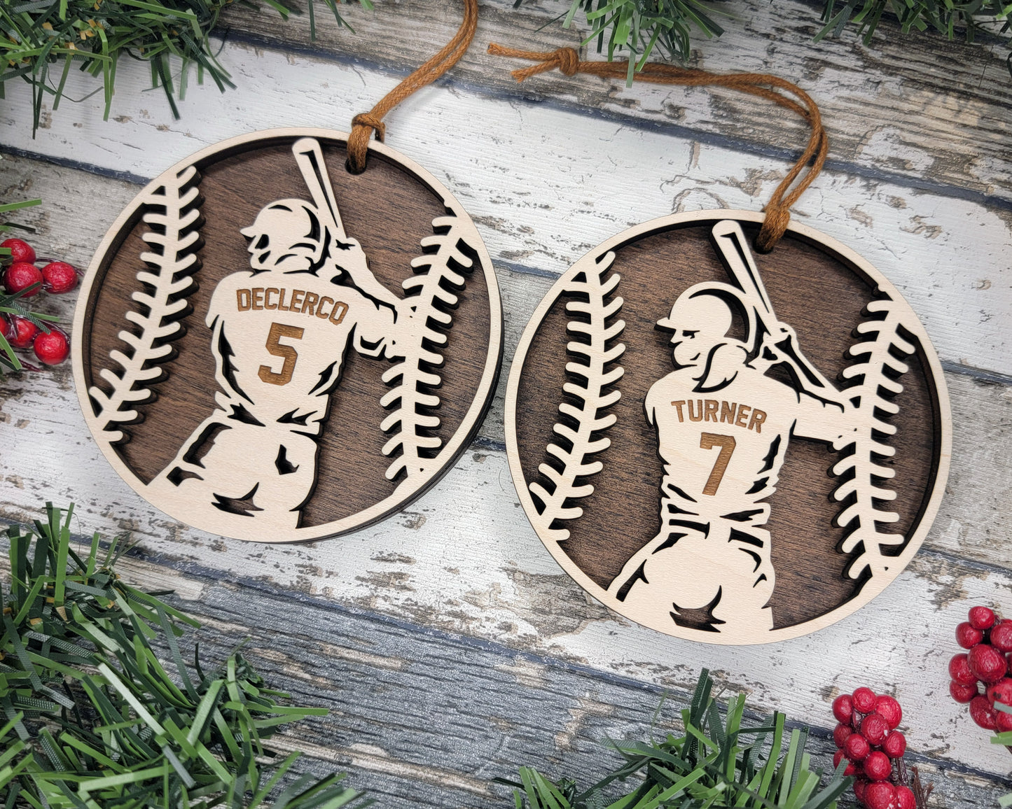 a pair of baseball ornament hanging from a christmas tree
