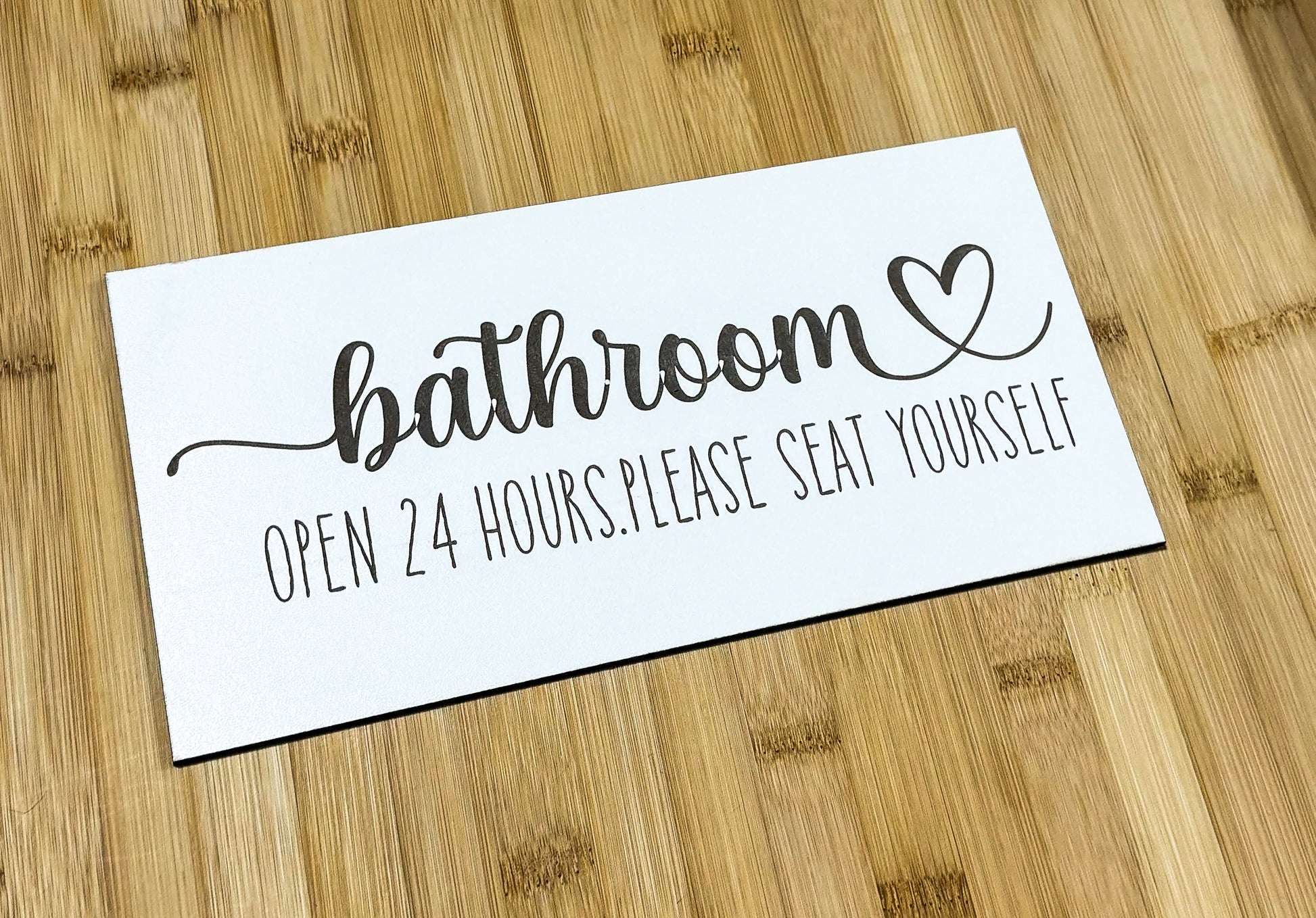 a bathroom sign sitting on top of a wooden table