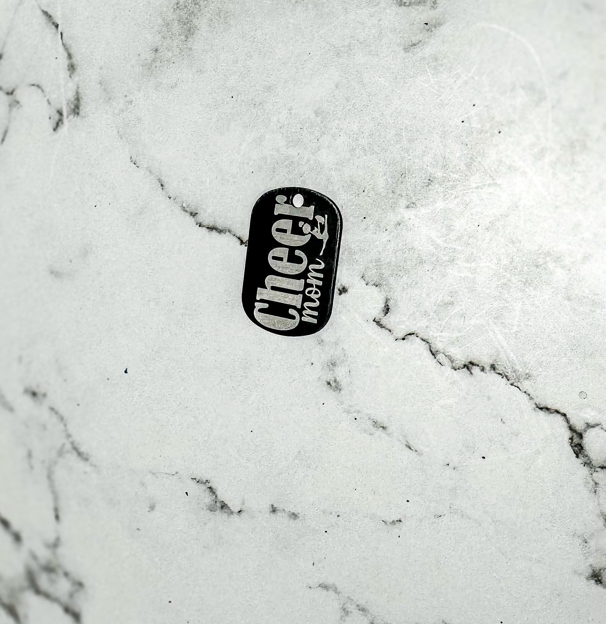 a black and white picture of a dog tag on a marble surface