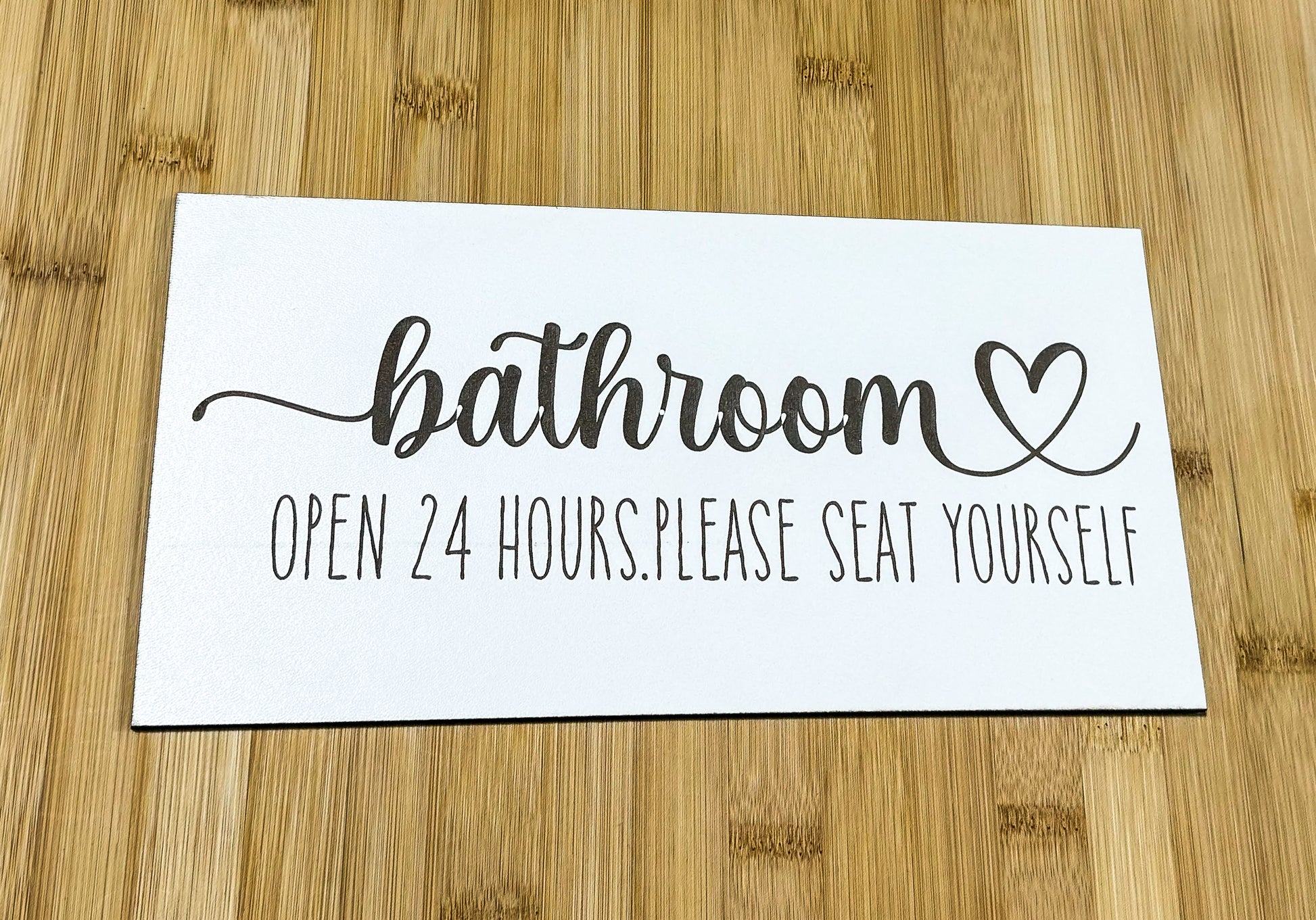 a bathroom sign on a wooden table with a wooden floor