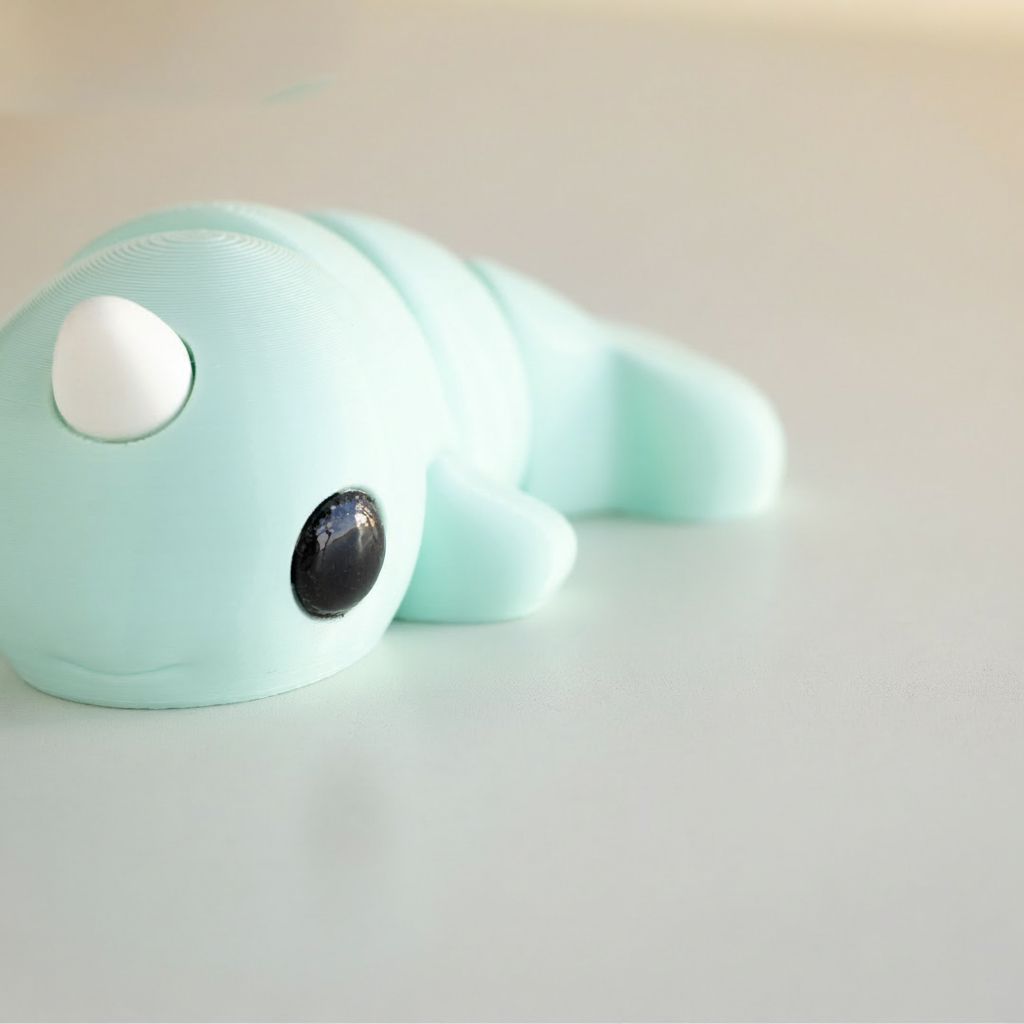 A light blue toy narwhal with a white horn is shown in the image.