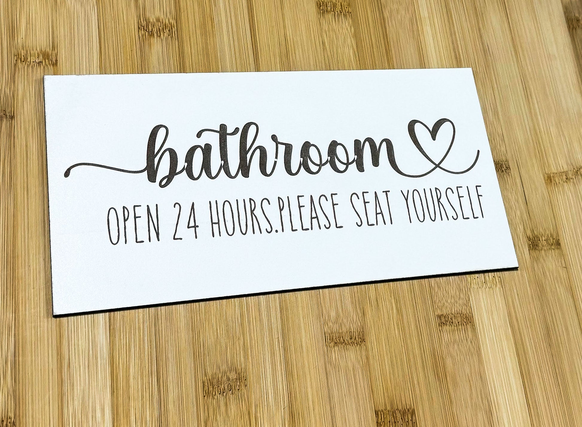 a bathroom sign sitting on top of a wooden table