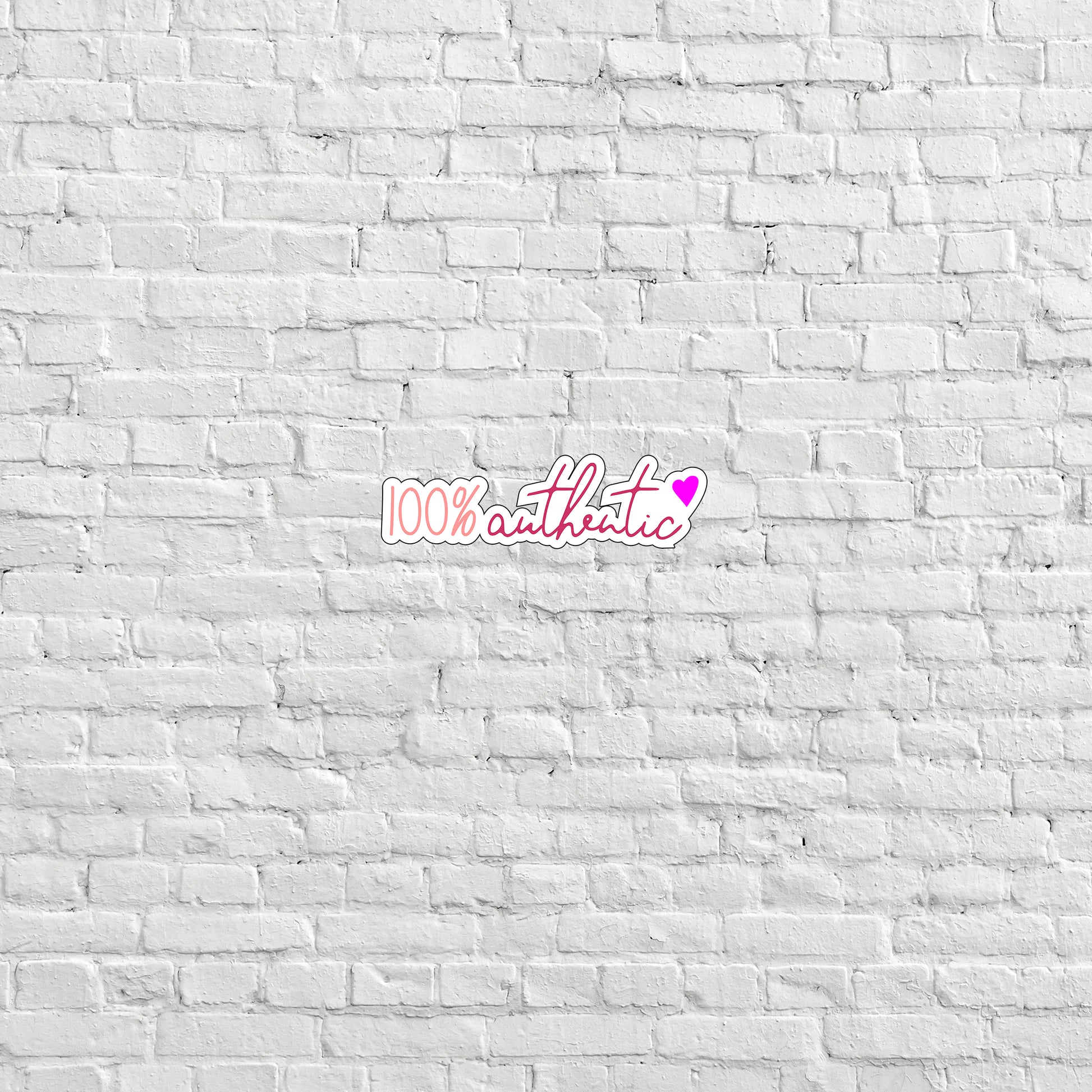 a white brick wall with a pink sticker on it